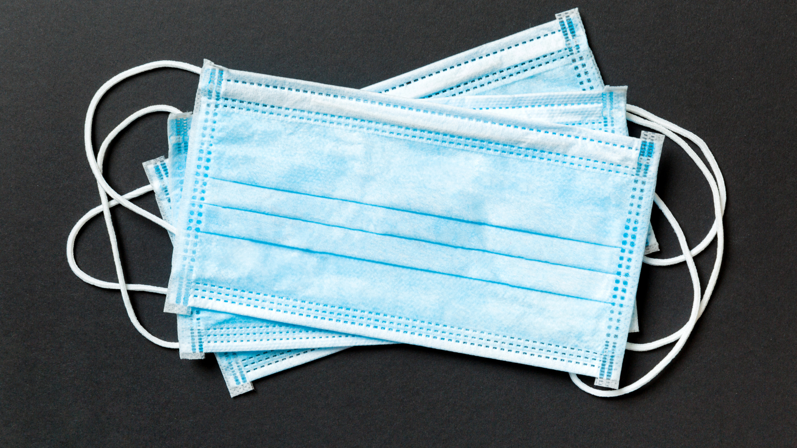 blue surgical masks on a black background